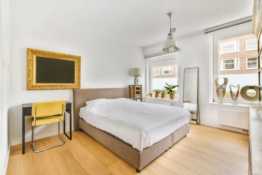 A bedroom with wooden floors and a bed.