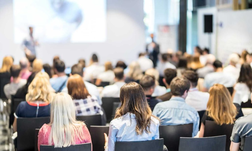 A group of people in a conference room watching a presentation.