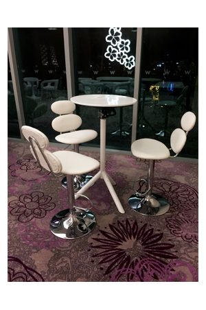 three marshmallow barstools and a round table in a hotel lobby