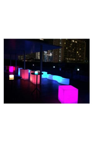 Illuminated cubes on a rooftop at night.