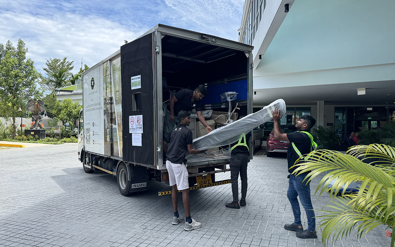 Logistics crew unloading furniture rentals from a delivery truck.
