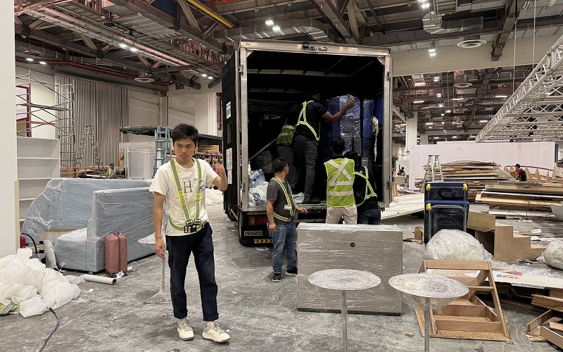 Logistics team unloading rented furniture for a convention event.