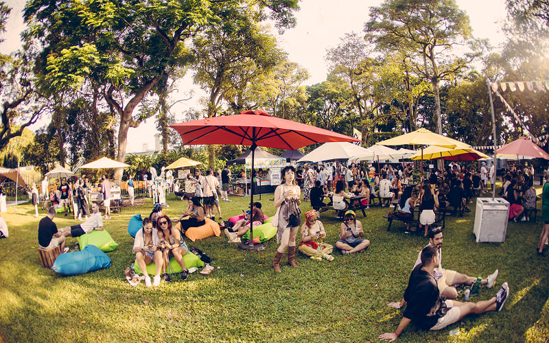 People relaxing on rented outdoor event furniture at a festival.